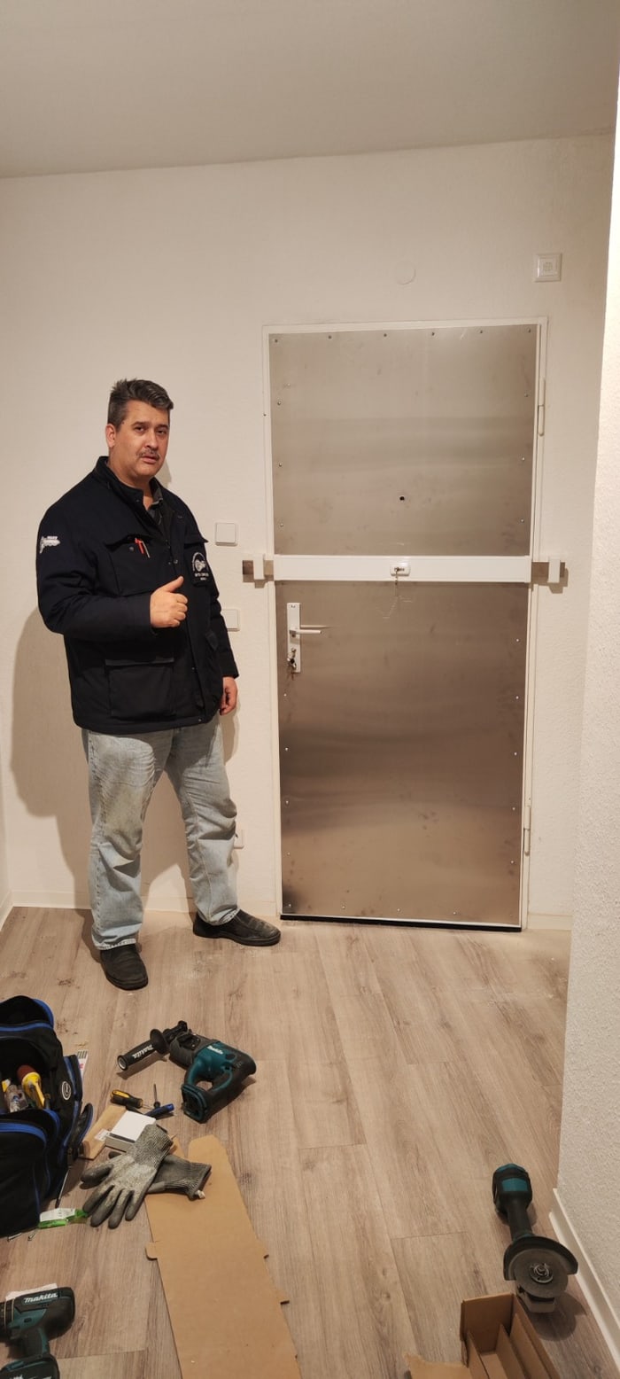 Falke Schwarzauge neben einer stahlverstärkten Tür mit Querriegel