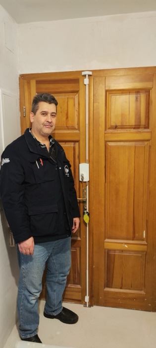 Falke Schwarzauge vor einer Tür mit montiertem Stangenschloss