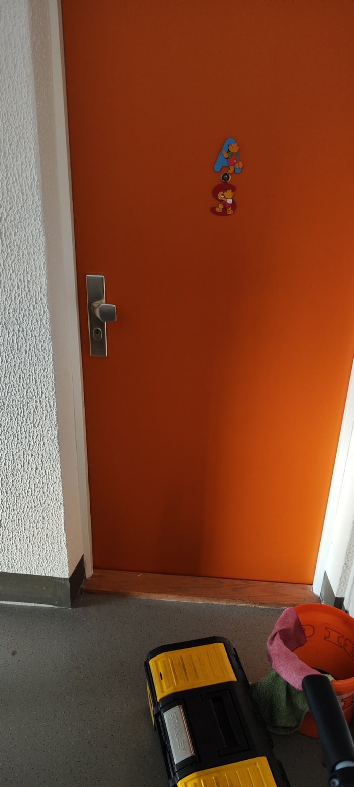 Orange Wohnungstür vor der Türöffnung – geschlossen